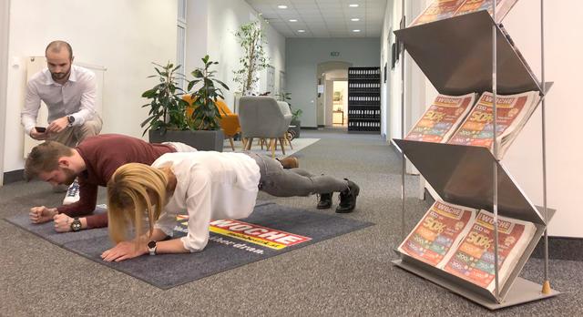 "Plank-Challenge": Kreativassistent Alexander Graimann und die Assistentin der Geschäftsführung Lisa Wohlgemuth zeigen es vor, Werbeberater Christoph Augustin dokumentiert genau. | Foto: WOCHE