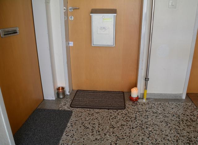 Hinter dieser Wohnungstür lag die junge Frau tagelang in der Abstellkammer. Ein Nachbar hat Kerzen aufgestellt.