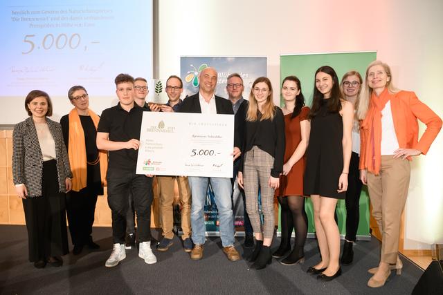 Projektleiter Mathias Weis mit dem Brennnessel-Award (5.v.l.) sowie Direktor Markus Berger (6.v.l.) und Schulqualitäts-Verantwortlicher Markus Krenn (7.v.l.) mit den Schülern der Wahlpflichtfachgruppe Biologie der 6. Klassen und den Jury-Mitgliedern der Stiftung Blühendes Österreich.