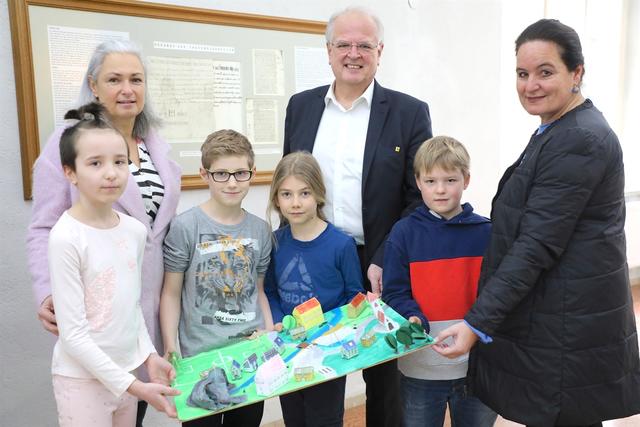 Die Schülerinnen und Schüler der Volksschule Egelsee Sonja Wagner, Dominik Rieder, Simon Tippl und Paul Hansal informieren gemeinsam mit ihrer Lehrerin Karina Peterschofsky Bürgermeister Dr. Reinhard Resch und Bildungsstadträtin Sonja Hockauf-Bartaschek über das Projekt Ortsgestaltung Egelsee.