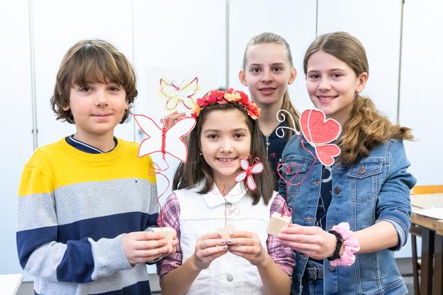 Fertige Kunstwerke: Strahlend zeigen Lukas, Debi, Julia und Vivia die fertigen Schmetterlinge aus handgeschöpftem Papier.