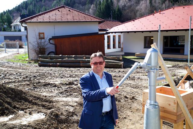 Bürgermeister Manfred Schuh beim Brunnenschwengel des Kindergartens. Der Spielplatzbereich soll schon bald begrünt sein.