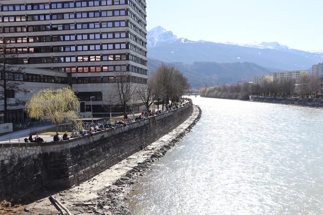 Während die Unis zu haben, sitzen die Studierenden auf der Mauer.