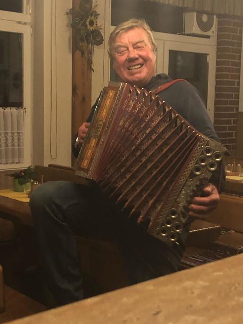 Julius Halper spielt im Heurigen mit seiner Harmonika auf.
