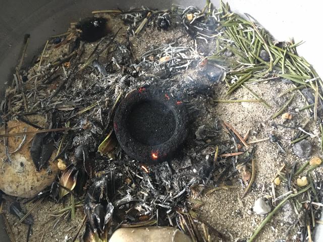 Die Räucherkohle mit der Zange halten und über einer Flamme vorsichtig entzünden.