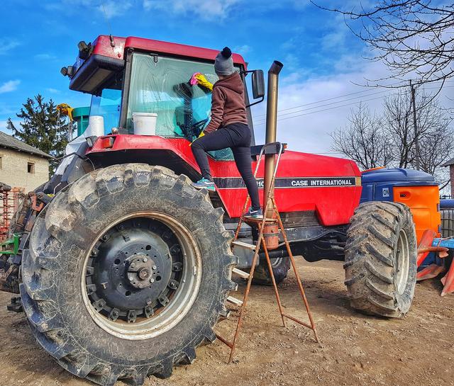 Auch eine sinnvolle Beschäftigung: Den Traktor putzen, damit er beim nächsten Mal sauber in den Gatsch fährt.