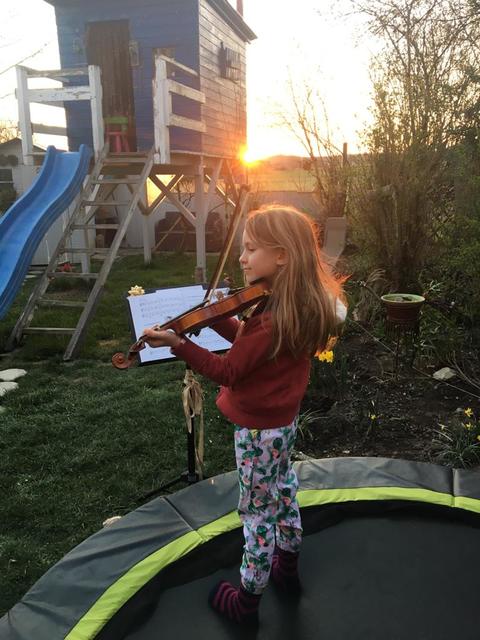 Das Trampolin nicht nur sportlich, sondern auch musikalisch nutzen: Schülerin Anna Benade übt auf ihrer Violine im Garten.