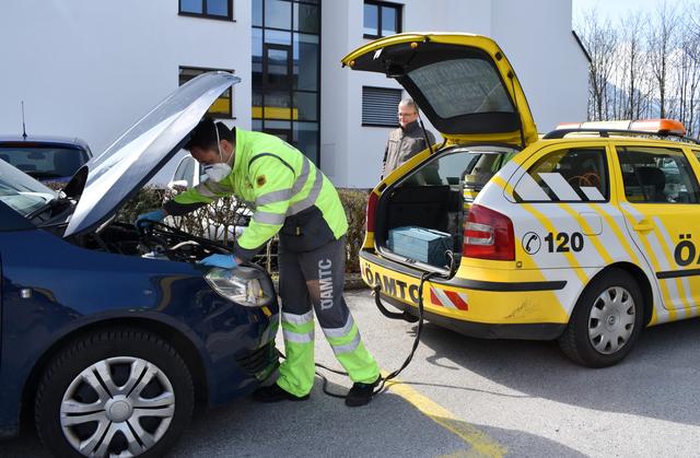 Beim Pannendienst wird um Abstand gebeten, während der Techniker mit Handschuhen und Mundschutz arbeitet.