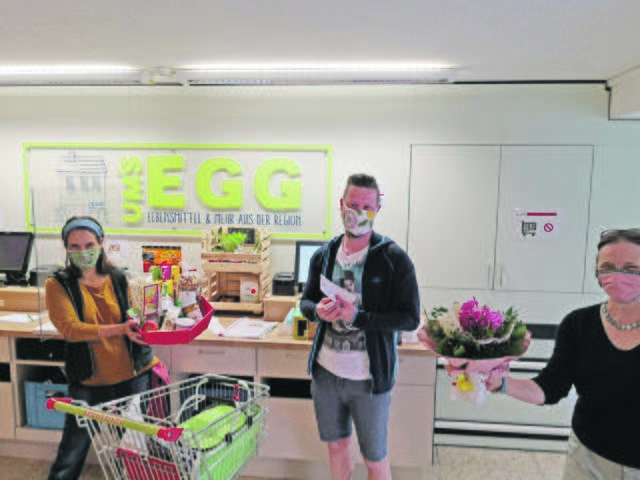 Abstand halten, Mundschutz tragen: Covid-19-bedingt wurden Blumen und Geschenkkorb ohne Händeschütteln und mit Mundschutz überreicht. Brigitte Kieweg (re.) übergab Blumen an den zehntausendsten Einkäufer Alexander Vorderderfler (Mitte).