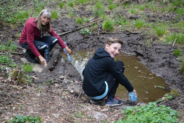 Nachfüllen im Froschteich, Maria Ringler und David Prix versorgen den Laichtümpel seit Wochen immer wieder mit mitgebrachten Wasserflaschen, um ein Austrocknen und damit den Tod der Kaulquappen zu verhindern. | Foto:  Veronika Spielbichler