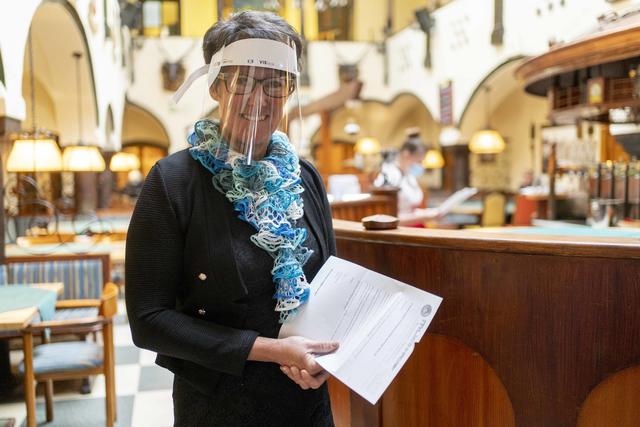 Gabriele Weiss mit Gesichtsschutzschild: Sie zieht im Arkadenhof im Hintergrund "die Fäden". | Foto: Klaus Pressberger