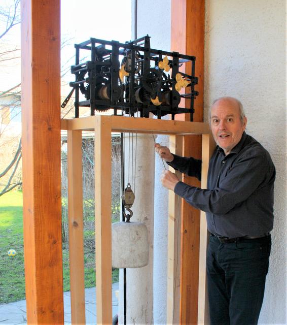 Michael Neureiter vor einem historischen Uhrwerk.