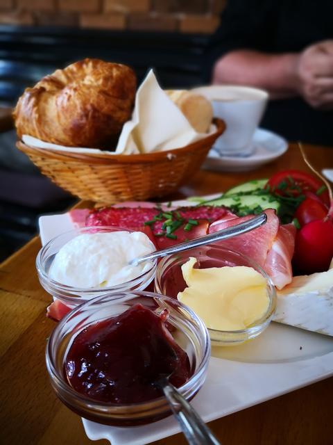 Kipferl, Marmelade und Kaffee werden zum Tisch serviert.