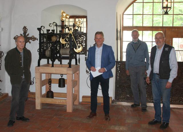 Bei der Übergabe hat es hat 11.10 Uhr geschlagen (v.l.): Kustos Richard Ruhland, Bürgermeister Andreas Bratzdrum, Schmiedemeister Hans Otty und der mit der Restaurierung beauftragte Michael Neureiter bei der Übergabe des Werks. Die Stunde wird in der alten Zeigerstellung durch den langen Zeiger, die Minute durch den kurzen Zeiger angegeben. Der neue Uhrstuhl wurde durch die Tittmoninger Firma Lechner Holzbau bereitgestellt. | Foto: Archiv Neureiter