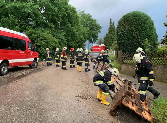 FF Maria Anzbach baut einen Damm zur Wasserumleitung aus Paletten und Folie