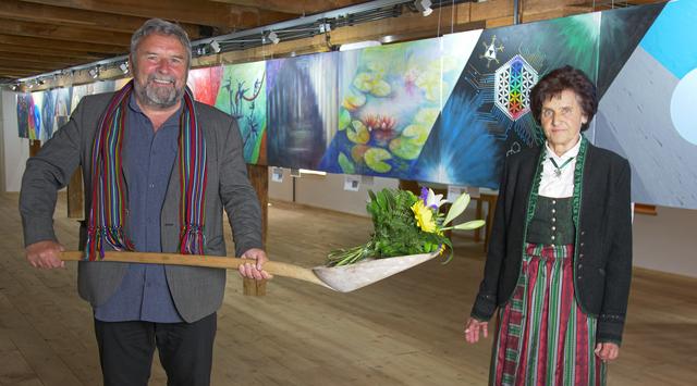 Desmond Doyle und Edda Hubmann: Um den corona-bedingten Sicherheitsabstand einzuhalten, wurde der Blumenstrauß mit Hilfe der originalen Mühlenschaufel des ehemaligen Besitzers Oskar Simon übergeben. Die Schaufel hat übrigens den Kosenamen „Alfons“. | Foto: Art Mine