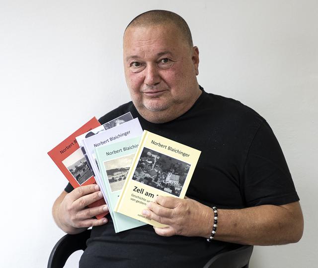Autor Norbert Blaichinger mit den insgesamt fünf Bänden über die Geschichte seines Heimatortes Zell am Moos.