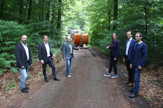 Landesrätin Barbara Eibinger-Miedl und Bürgermeister Siegfried Neuhold (3.v.l.) auf der Baustelle mit: Der Layjet verlegt die Leerverrohrungen in einem Arbeitsschritt.