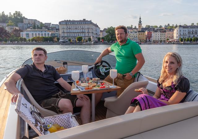 Die Gäste genießen ihr Frühstück auf einem Frauscher-Mietboot von Dominik Huber (m.)