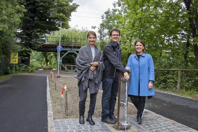 Vizebürgermeisterin Uschi Schwarzl, Referatsleiter Markus Pinter und Gemeinderätin Julia Seidl testeten den neuen Trinkbrunnen bei der Karwendelbrücke.