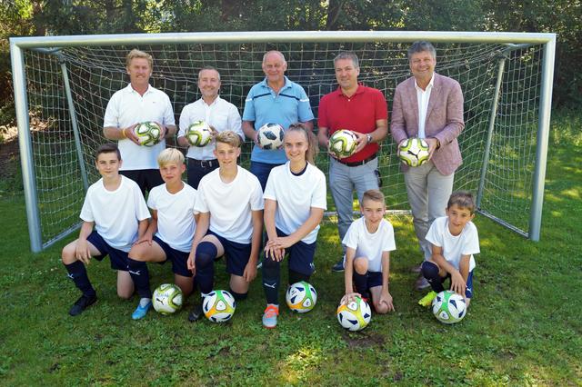Am Ball: Standortleiter Mario Hofer, die organisatorischen Leiter Willi Pflügl und Sigi Grutschnig, Vizebürgermeister Andreas Unterrieder und Bürgermeister Gerhard Pirih mit den Nachwuchskickern David Miskovic, Roman Kassmannhuber, Samuel Lesacher, Selina Selinger, Maximilian Pflügl und Timo Huber.