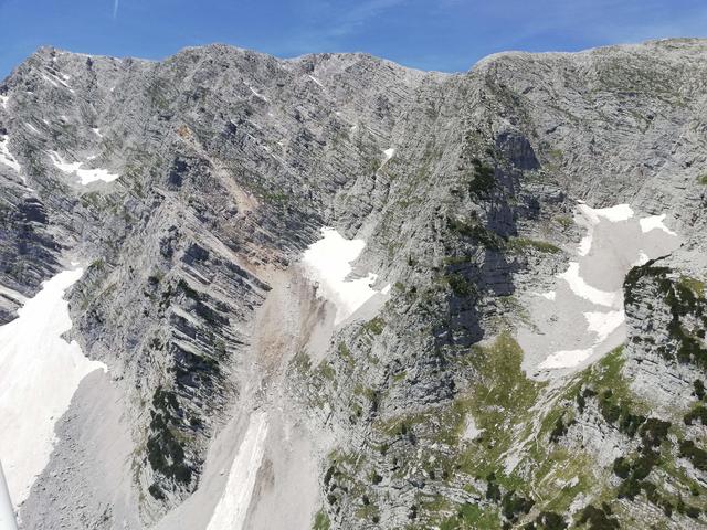 Aus der Luft betrachtet sieht man die rötliche Abbruchkante des Felssturzes besonders schön.
