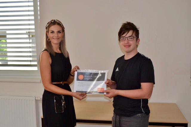 PTS Hartberg-Direktorin Simone Gangl gratuliert Tobias Kogler zur Microsoft-office-Zertifizierung.