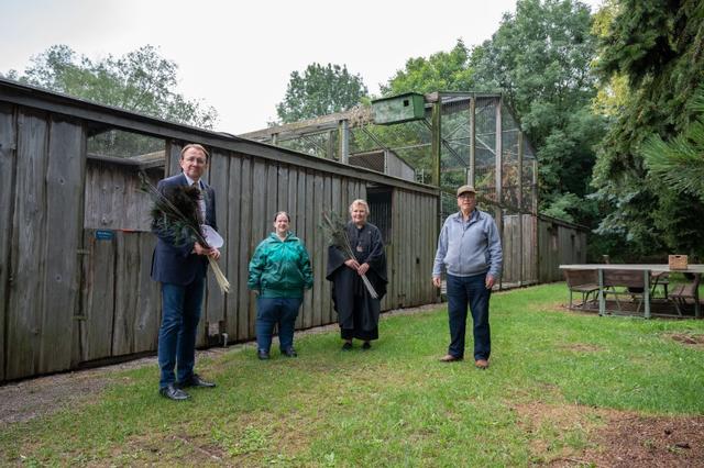 Bürgermeister Matthias Stadler und die Gemeinderätin Birgit Becker aus St. Georgen bekommen bei ihrem Besuch auf der Greifvogelstation ein paar Pfaufedern geschenkt. Peter Steinbichl wird von seiner Tochter Sylvia Steinbichl bei der Pflege der Vögel tatkräftig unterstützt. | Foto:  Arman Behpournia