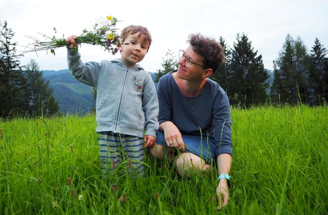 ein kleine Kavalier pflückt einen Blumenstrauss für seine Mutter