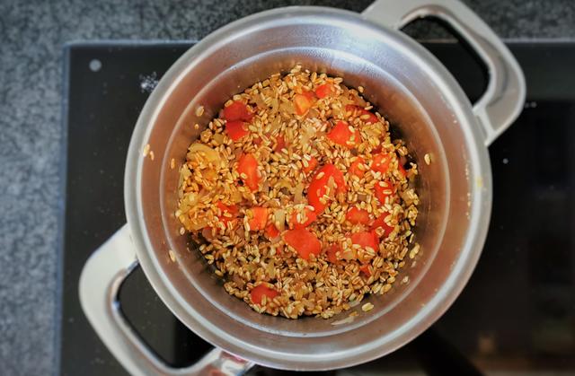 Dinkelreis wird mit Zwiebel, Knoblauch und Tomatenwürfel gedünstet | Foto: Katrin Ebetshuber