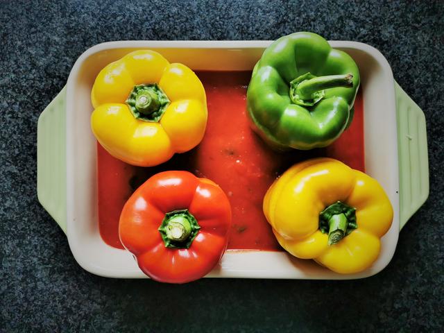 die gefüllten Paprika werden in einer Auflaufform in der Tomatensauce im Ofen gebacken | Foto: Katrin Ebetshuber