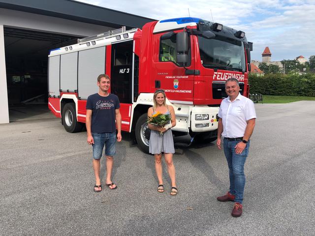 Feuerwehrkommandant Stefan Langzauner, Bianka Furtlehner und Ortsvorsteher Anton Geister – Ein Strauß Blumen für die verletzte Kameradin der FF Ulmerfeld-Hausmening für den unermüdlichen Einsatz