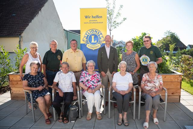 Karl Kronberger (PR-Beauftragter des LC Kreuzenstein) und Herbert Grundschober (beide im grünen Polo) sowie der neue Präsident Andreas Stemberger (rechts vom Rollup) übergeben an Bürgermeister Josef Anzböck und die Bewohner die beiden Hochbeete.