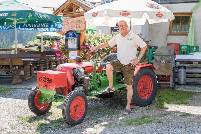 Oldtimer sind seine große Leidenschaft: Franz Wurm mit seinem Oldtimertraktor, der das Wirtshaus ziert.