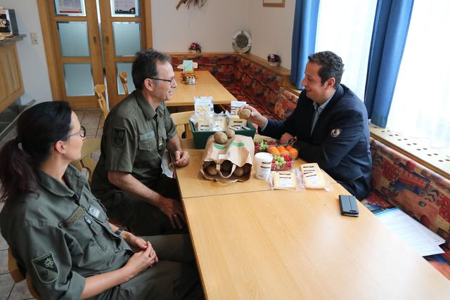 Bernhard Pircher (re). präsentiert dem Wirtschaftsoffizier, Oberstleutnant Markus Kecht, und der Leiterin der Truppenküche, Oberstabswachtmeister Christiane Karlinger, die Produkte aus Landeck.