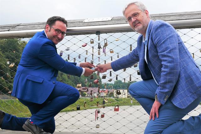 Der zweite Präsident des Salzburger Landtags Sebastian Huber (Neos) und Tobias Gotthardt, Europaausschussvorsitzender im Bayrischen Landtag hängten ein Freundschaftsschloss am Europasteg in Oberndorf auf.