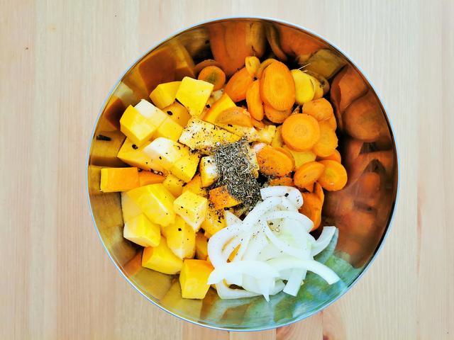 Kürbis, Karotten und Zwiebel werden mit Öl und Gewürzen mariniert | Foto: Katrin Ebetshuber