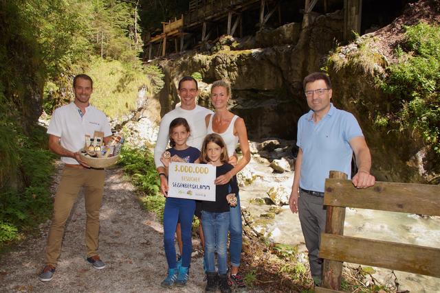 3.000.000 Besucher: Wolfgang Fegg (Geschäftsführer vom Salzburger Saalachtal Tourismus, li.) und Bürgermeister Josef Hohenwarter (rechts) freuen sich über Familie Grimser – den dreimillionsten Besuchern der Seisenbergklamm. | Foto: Gemeinde Weißbach