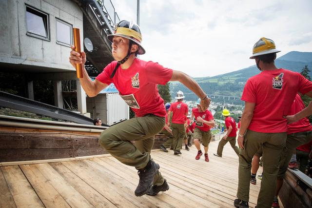 Die Feuerwehr-Staffeln kämpfen sich in Montur und mit Helm die Paul-Außerleitner-Schanze hinauf. | Foto: Philipp Schuster/Red Bull Content Pool