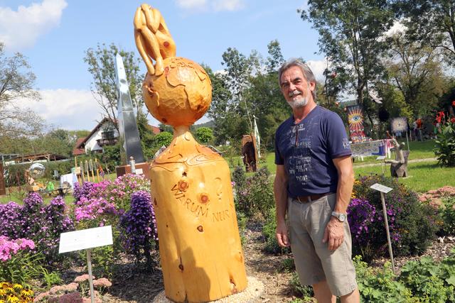 Holzschnitzer Hans Pendl vor seiner Zirbenholz-Skulptur "Warum nur, Mensch?"