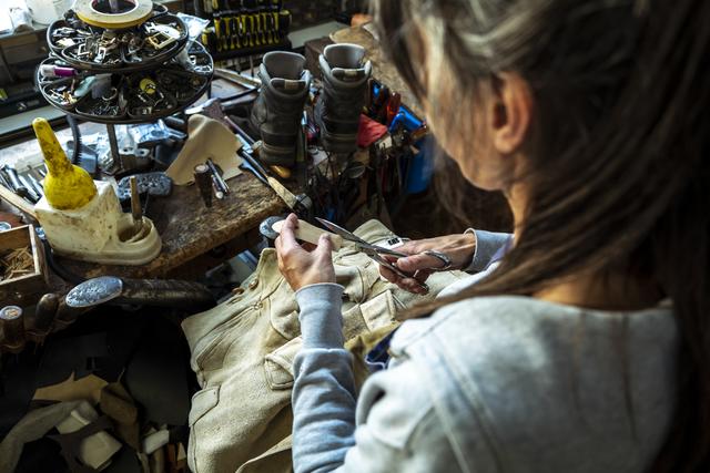 Die Schusterin kümmert sich nicht nur um defekte Schuhe, sie repariert auch Lederhosen.