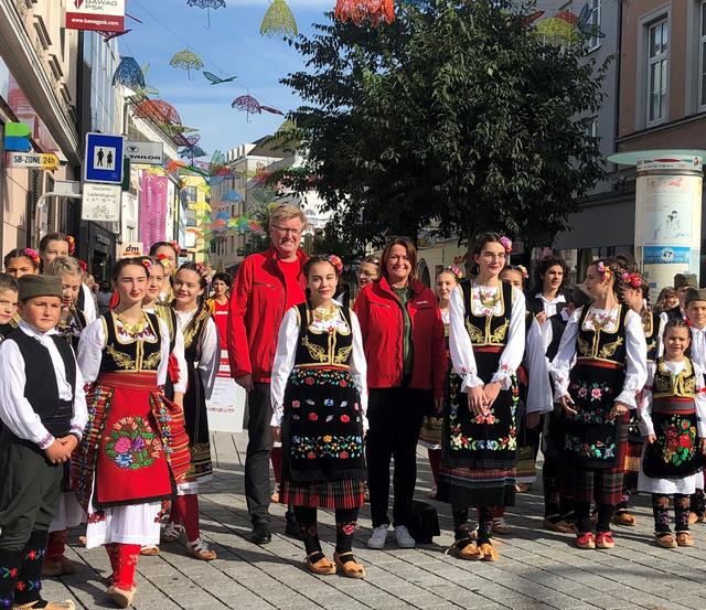 Volkshilfe-Wels-Kirchdorf-Vorsitzender Johann Reindl-Schwaighofer und seine Stellvertreterin Petra Wimmer mit Mitgliedern der serbischen Kinder-Tanzgruppe.