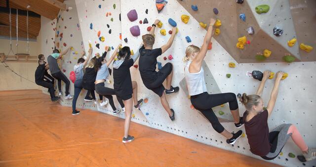 Die Lehrlinge erklimmen die Kletterwand.