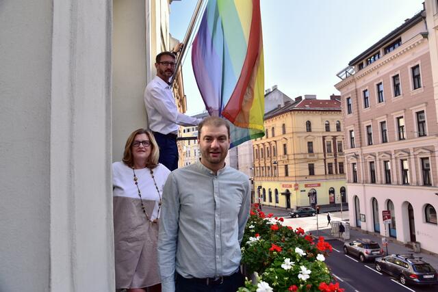 Bezirkschefin Susanne Schaefer-Wiery mit Thomas Kerekes (vorne) und Markus Österreicher beim Hissen der Regenbogenflagge am Amtshaus.
