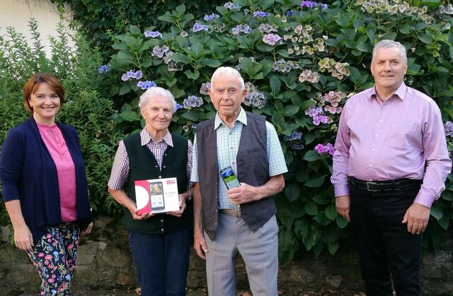 Emporia Schulungsleiterin Sigrid Prammer übergibt Josef Wiesinger und seiner Frau Adelheid ein Senioren-Smartphone. Rechts im Bild Leopold Wipplinger vom Seniorenbund.