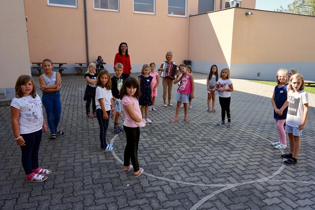 Fröhliche Schülerinnen und Schüler bei der Musik- und Chorstunde mit Lehrerin Doris Hicker und Direktorin Brigitte Hipfinger im Schulhof der Volksschule Laa an der Thaya.