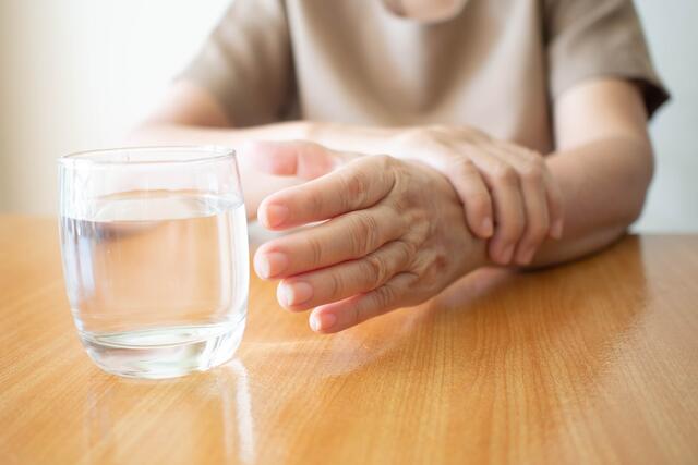 Ein Glas Wasser in die Hand zu nehmen, kann für Parkinson-Patienten eine große Herausforderung sein.