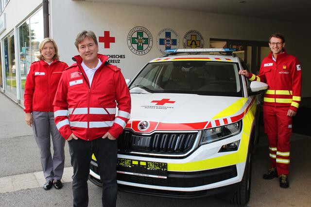Landesgeschäftsführerin des Roten Kreuzes Salzburg Sabine Kornberger-Scheuch, Daniell Porsche und der Leitende Notarzt Wolfgang Fleischmann mit dem gespendeten Auto.