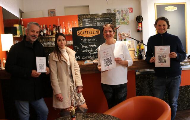 Walter Innerebner und Stefanie Pittracher (beide IT-Innerebner), Petra Rainer-Scartezzini und Michael Gsaller (Stadtmarketing Hall in Tirol) präsentieren die Gästeregistrierung mittels QR-Code bei Feinkost Scartezzini in Hall