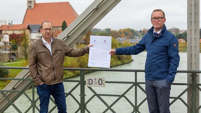Bürgermeister Feil (Laufen) und Djundja (Oberndorf) mit dem offenen Brief an der Staatsgrenze auf der Länderbrücke zwischen Laufen und Oberndorf.